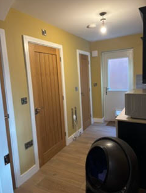 Yellow hallway with wooden doors and white trim